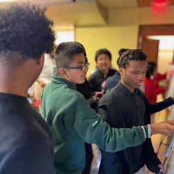 group of students placing sticky notes on whiteboard