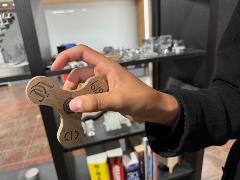 Student holds Fidget Spinner made out of wood using laser cutter