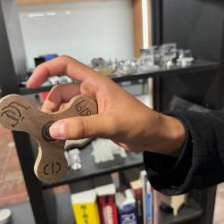 StudentholdsFidgetSpinnermadeoutofwoodusinglasercutter