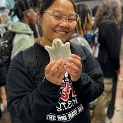 student2 holding up a ghost 3D printed artifact