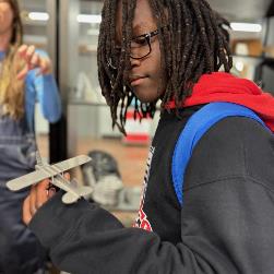 Student2 holds example of medal fabrication of model plane